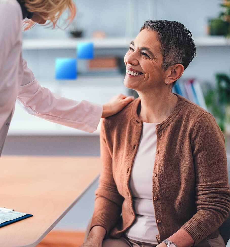 Patient smiling while speaking with a health care provider during an office visit.